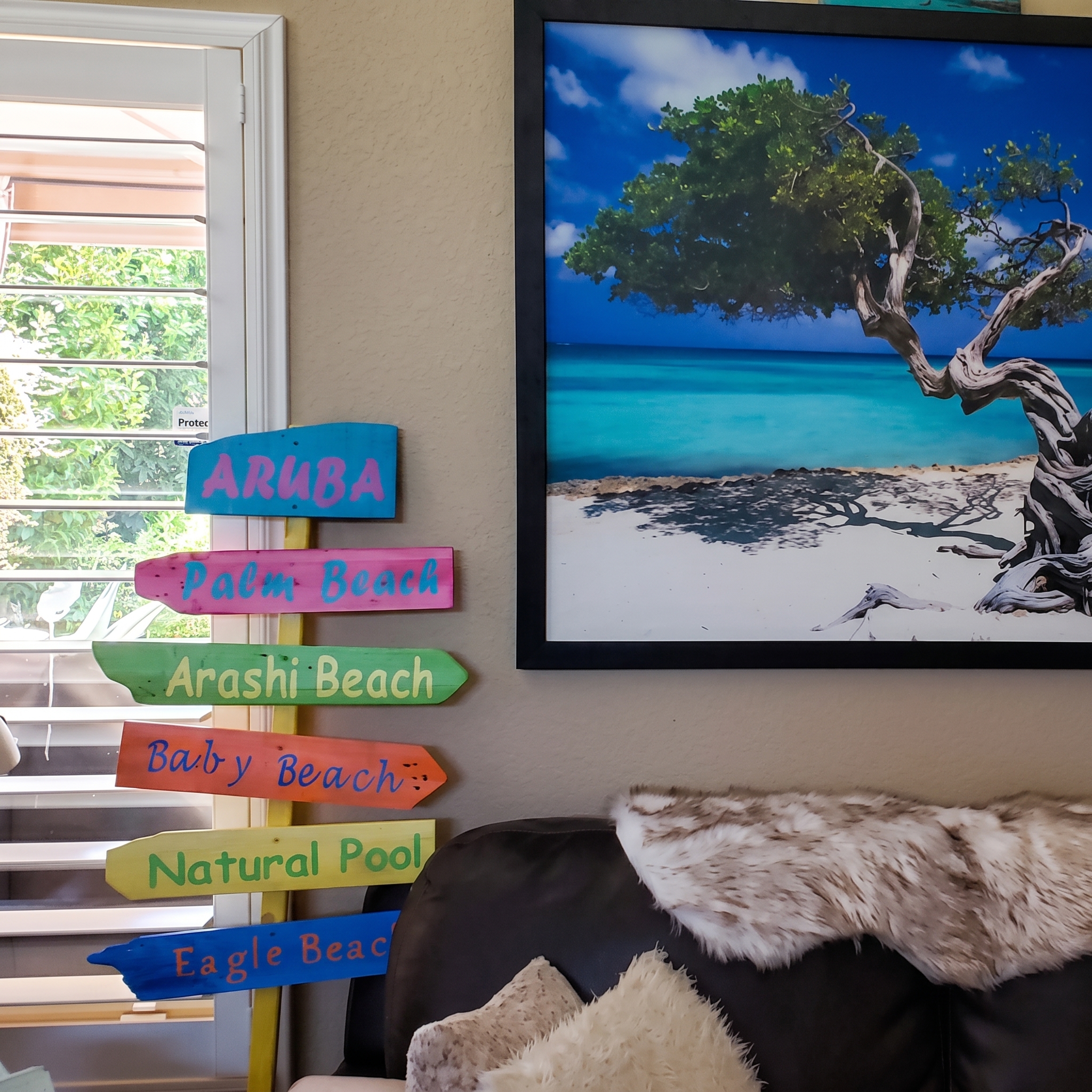 Aruba sign displayed indoors beside a photo of Aruba