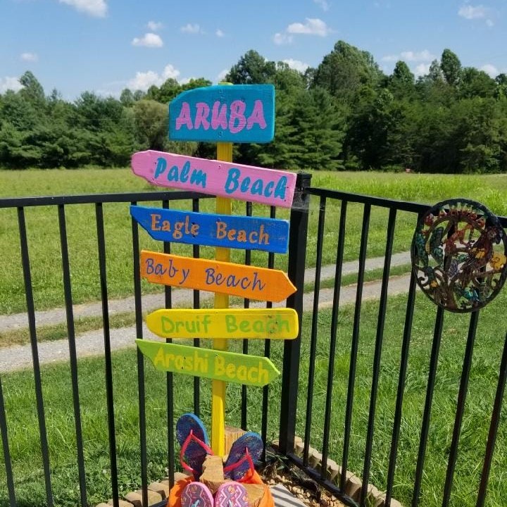 Aruba sign on a deck overlooking an open green field