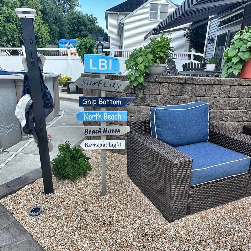 An LBI sign in a gravel yard beside patio furniture