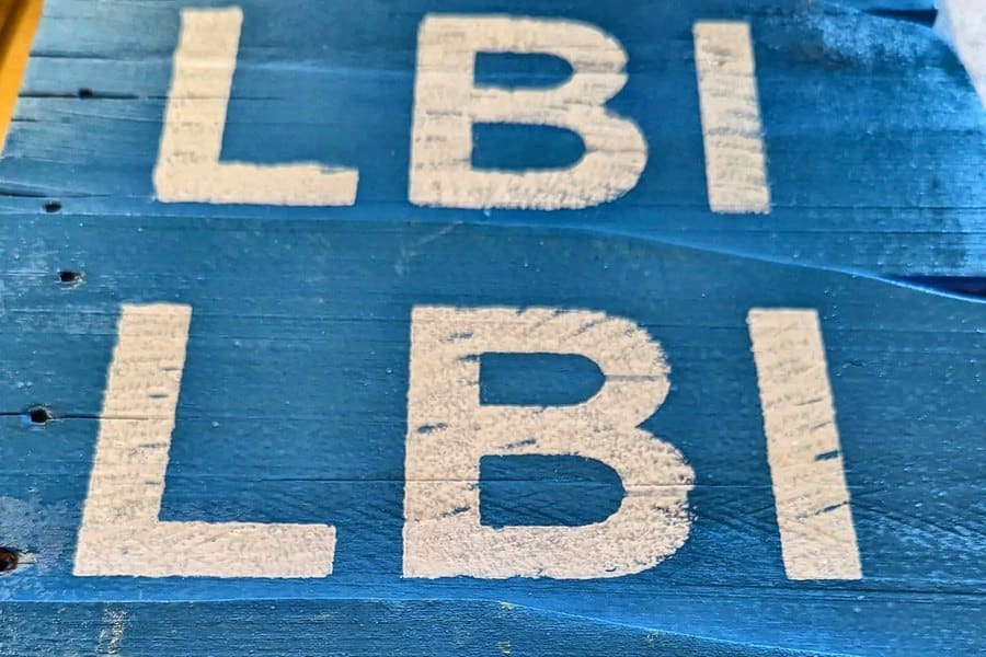 Close-up of weathered painted boards showing real grain and nail holes